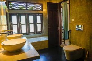 a bathroom with a tub and a toilet and a sink at Villa Milla Walauwa in Matale
