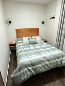 een slaapkamer met een groot bed en een groen dekbed bij Departamento Roma 1 CDMX in Mexico-Stad