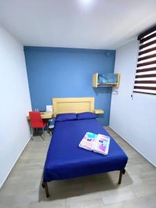 Habitación azul con cama y mesa en Hostal Talavera, en Puebla