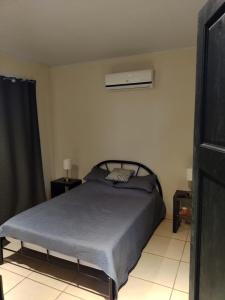 - une chambre avec un lit et la climatisation dans l'établissement Casa Mangos, à Orotina
