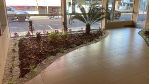 a hallway of a building with a plant at Perola Verde Hotel in Birigui