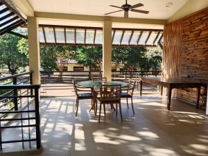 a screened porch with a glass table and chairs at Villa Marilyn Resort and Hotel in Coron
