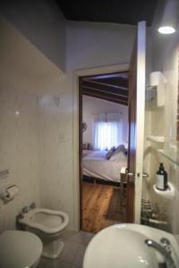 1 cama y baño con lavabo y aseo. en Hostería Carelhue en San Carlos de Bariloche