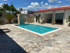 a swimming pool in front of a house at Perola Verde Hotel in Birigui