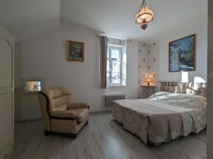 a bedroom with a bed and a chair at Belle maison en pierre au cœur du Berry avec jardin, terrasse, et activités familiales à proximité - FR-1-591-152 in Pérassay