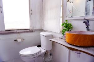 a bathroom with a toilet and a wooden sink at The 99 Cottage (บ้านทุ่งบางปลาม้า) in Suphan Buri +39 photos