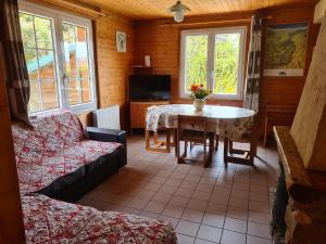 ein Wohnzimmer mit Tisch und Couch in der Unterkunft Chalet confortable avec cheminée proche de La Bresse-Hohneck, idéal pour famille et amis. - FR-1-589-123 in La Bresse