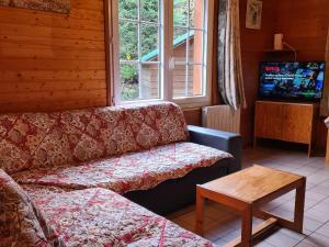 ein Wohnzimmer mit Sofa und Tisch in der Unterkunft Chalet confortable avec cheminée proche de La Bresse-Hohneck, idéal pour famille et amis. - FR-1-589-123 in La Bresse