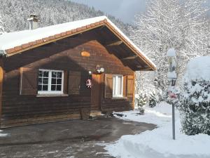 a log cabin in the snow with a door at Gîte La Bresse, 3 pièces, 4 personnes - FR-1-589-130 in La Bresse
