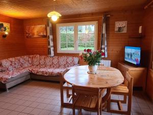 ein Wohnzimmer mit Tisch und Couch in der Unterkunft Chalet Confortable à La Bresse, Proche Ski, Wifi, Animaux Acceptés - FR-1-589-130 in La Bresse