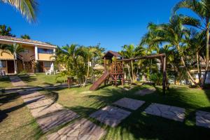 a playground in front of a house with palm trees at Hotel Latitud Buzios by Latitud Hoteles in Búzios