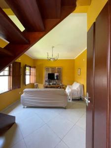 um quarto com uma cama grande e paredes amarelas em Casa Portal em Paraty