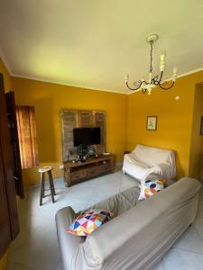 uma sala de estar com um sofá e uma televisão em Casa Portal em Paraty