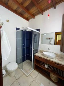 uma casa de banho com um chuveiro, um WC e um lavatório. em Casa Portal em Paraty