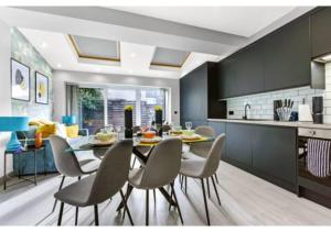 a kitchen and dining room with a table and chairs at Three Bedroom Home - Perfect for Large Groups in London