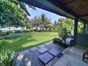 uitzicht op de tuin vanaf de veranda van een huis bij SuperSuck Hotel in Maluk