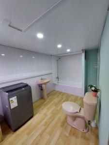 uma casa de banho com um WC cor-de-rosa e um lavatório. em Cabaña Frente Al mar, Carretera Austral km 38,6, Puerto Montt em Puerto Montt