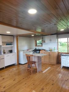 uma cozinha com uma mesa e uma cadeira num quarto em Cabaña Frente Al mar, Carretera Austral km 38,6, Puerto Montt em Puerto Montt