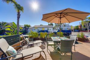 a table and chairs with an umbrella on a patio at Stunning Beach Home - large patio, parking, ac & dog friendly! in San Diego