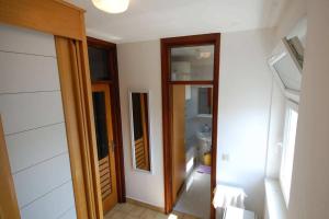 um quarto com uma casa de banho com uma porta e um espelho em Apartments with a parking space Njivice, Krk - 21866 em Njivice