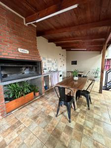 a dining room with a table and chairs and a brick wall at LA SELVA MONOAMBIENTES in Puerto Iguazú