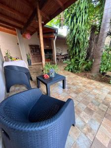 a patio with two blue chairs and a table at LA SELVA MONOAMBIENTES in Puerto Iguazú