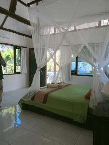 a bedroom with a green bed with a canopy at Gili Hideaway in Gili Trawangan
