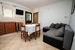 ein Wohnzimmer mit einem Tisch und einem Sofa in der Unterkunft Family friendly apartments with a swimming pool Njivice, Krk - 21862 in Njivice