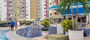 a swimming pool with palm trees and buildings at PRIVÉ DAS THERMAS I apto 1001C in Caldas Novas