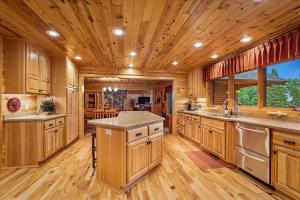 a kitchen with wooden cabinets and a wooden ceiling at Woodhaven On Leech Lake in Cass Lake