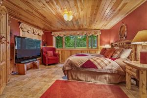 1 dormitorio con 1 cama y TV de pantalla plana en Woodhaven On Leech Lake en Cass Lake