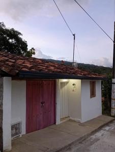 a house with a red door and a garage at Casa Betania, entorno natural in Páramo