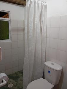 y baño con aseo y cortina de ducha. en Casa Betania, entorno natural, en Páramo