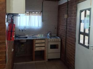 a small kitchen with a sink and a stove at Alberto Beach in Las Grutas