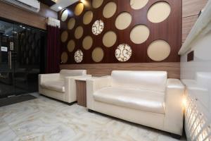 2 sillas de cuero blanco en una sala de espera en Hotel Us Residency en Kakarmatha