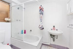 biała łazienka z prysznicem i umywalką w obiekcie Urban Chic Studio By 'the Strip' w mieście Perth