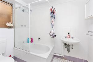 a white bathroom with a shower and a sink at Urban Chic Studio by 'the Strip' in Perth