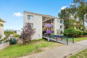 a white house with purple benches in front of it at Urban Chic Studio by 'the Strip' in Perth