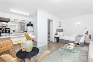 a living room with a table and a room with a kitchen at Urban Chic Studio by 'the Strip' in Perth