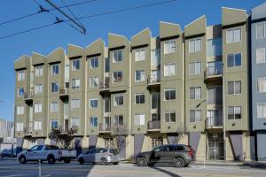 サンフランシスコにあるMid-Century Loft in SoMa - Steps to Caltrain!の車が目の前に停まったアパートメントビル