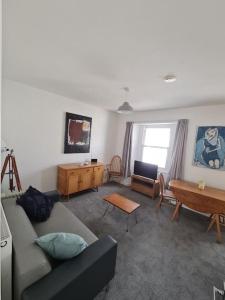 uma sala de estar com um sofá e uma mesa em bEaUtiFUL and Bright !! Town/Harbour apartment #2 em Penzance
