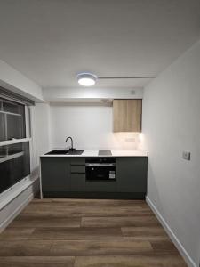 an empty kitchen with a sink and a counter at bEaUtiFUL and Bright !! Town/Harbour apartment #2 in Penzance