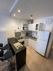 a kitchen with a white refrigerator and a counter top at Tu casa en parque in Necochea