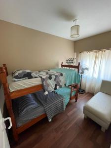 ein Schlafzimmer mit einem Etagenbett und einem Sofa in der Unterkunft Tu casa en parque in Necochea