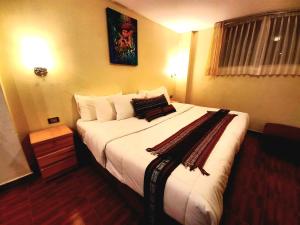 ein Schlafzimmer mit einem großen Bett mit weißer Bettwäsche und Kissen in der Unterkunft Hotel Humantay Lodge Ollantaytambo in Ollantaytambo
