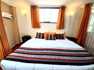 a bedroom with a large white bed with a window at Hotel Humantay Lodge Ollantaytambo in Ollantaytambo