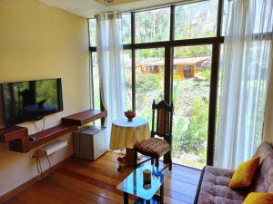 a living room with a large window and a couch at Hotel Humantay Lodge Ollantaytambo in Ollantaytambo