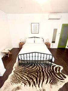 1 dormitorio con 1 cama con alfombra de cebra en el suelo en Beautiful 1 BR Art DECO Inspired en Filadelfia