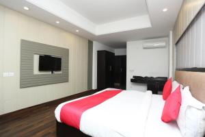 um quarto com uma cama e uma televisão na parede em Super OYO The Avenue Residency Near Leisure Valley Park em Gurgaon