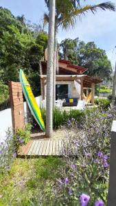 a surfboard sitting next to a house at Residencial Bombinhas Pé na Areia in Bombinhas